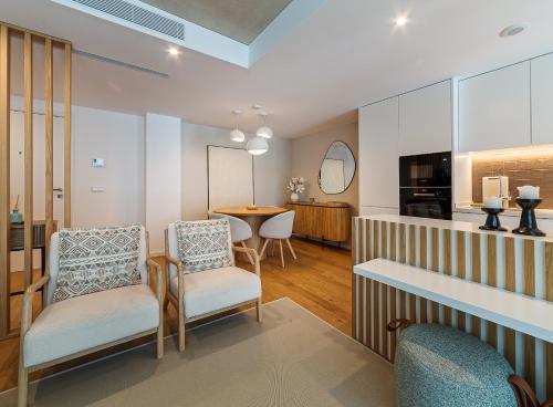 a living room with two chairs and a table at Lina Beach Villa by Home Sweet Home Aveiro in Praia da Barra