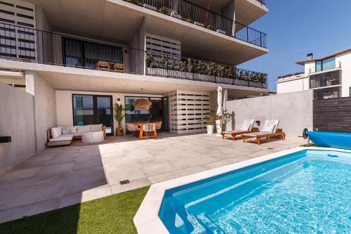 a swimming pool in the backyard of a house at Lina Beach Villa by Home Sweet Home Aveiro in Praia da Barra