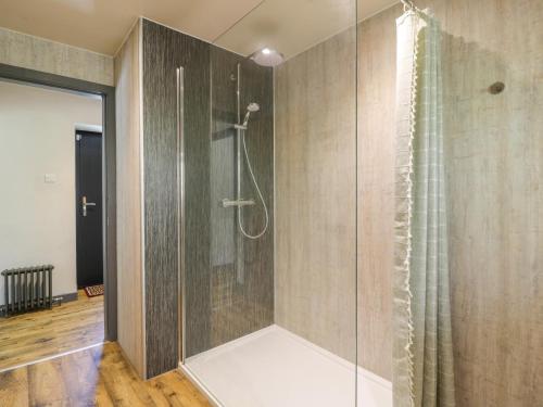 een badkamer met een douche met een glazen deur bij Nithbank Cottage in Thornhill