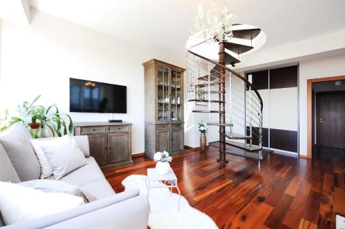 a living room with white furniture and a tv at Sunset Penthouse Apartment with Jacuzzi and Seaview in Zadar