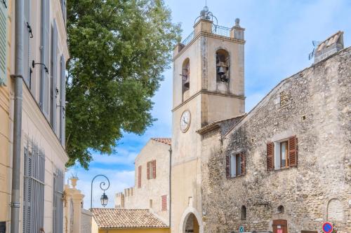 an old building with a clock tower on a street at Grimaldi in Cagnes-sur-Mer