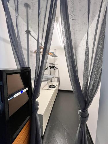 マリーナ・ディ・アンドーラにあるMaison Art sur la Merのテレビ、カーテン付きの部屋