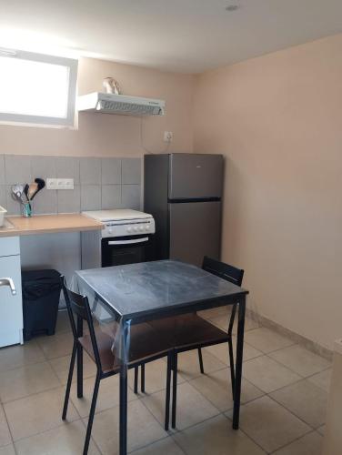 une petite cuisine avec une table et un réfrigérateur dans l'établissement Studio La Gière, à Beaumes-de-Venise
