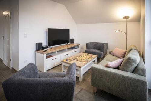 a living room with two couches and a tv at VechteSchober in Nordhorn