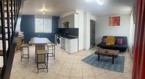 une cuisine et un salon avec un canapé et une table dans l'établissement Sweet Harmony - Appart spacieux, à Aulnay-sous-Bois