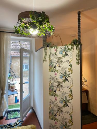 a room with a curtain and a window and a chandelier at Chambre d'hôtes 2 - Exotique - Un Refuge à Cachen in Cachen