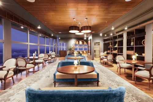 a lobby with tables and chairs and windows at Le Meridien New Delhi in New Delhi