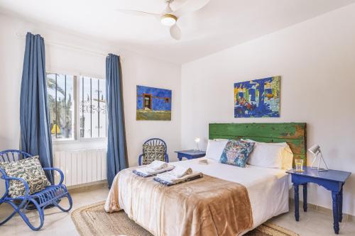a bedroom with a bed and two chairs and a window at Casa Grande in Jávea