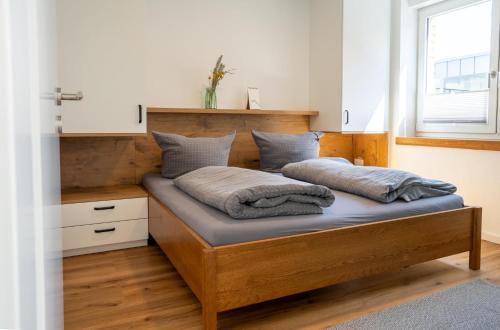 una camera da letto con un letto con testiera in legno di STRANDHAUS GRÖMITZ 2 a Grömitz