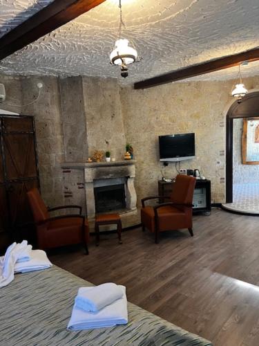 a living room with a fireplace and chairs and a tv at LA BİEN ALAÇATI in Cesme