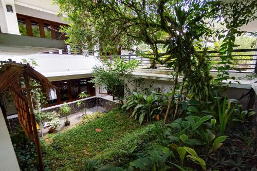an external view of a building with a garden at Urbanview near Pasir Angin Hotel in Gadok 1
