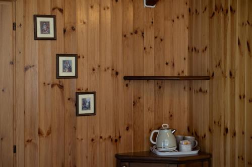 a room with a wooden wall with a tea kettle on a table at Agriturismo Alberobello in Viganella