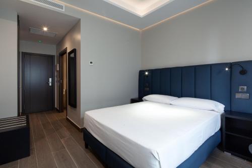 a bedroom with a large bed with a blue headboard at Leflet Sanlucar in Sanlúcar la Mayor