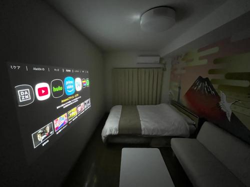 a small room with a bed and a wall with stickers at Camelot Annex in Fukuoka