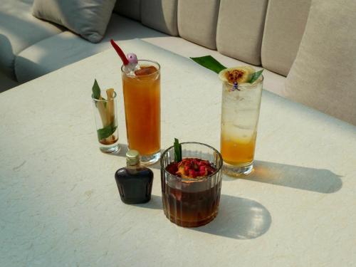 a white table with three drinks on it at The Fig Lobby Bangkok in Bangkok