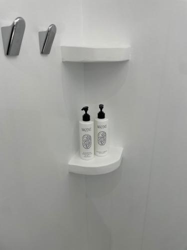 two bottles ofodorizers on a shelf in a bathroom at Aegean Bliss - Stylish Stay in Agios Stefanos in Agios Stefanos