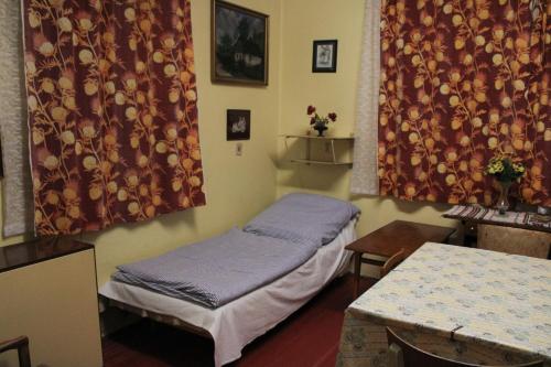 a room with a bed and a table and curtains at Prázdniny u babičky in Česká Třebová