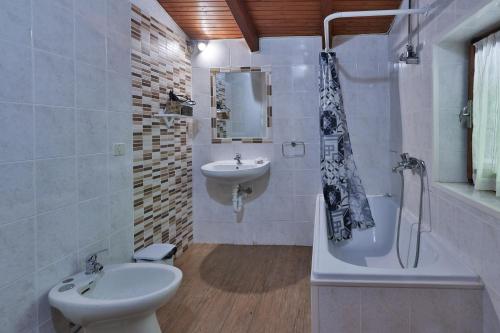 a white bathroom with a sink and a toilet at Agriturismo Alberobello in Viganella