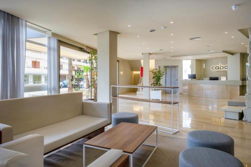 a lobby with a couch and a table and chairs at Cabot Cap de Mar Spa in Cala Bona