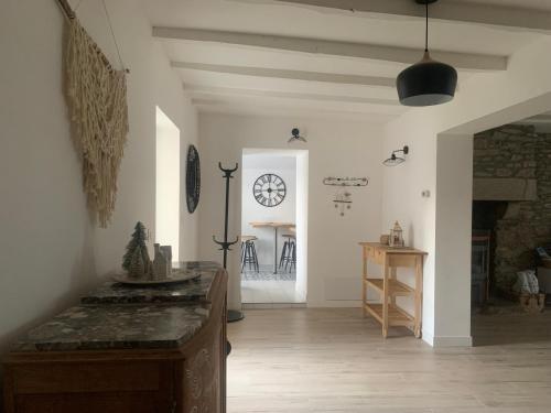 un salon avec une horloge au mur dans l'établissement Maison KERVOYAL DAMGAN 8 personnes, plage à pied, à Damgan
