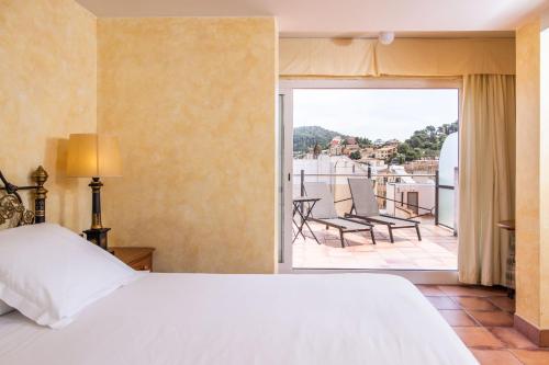 a bedroom with a bed and a balcony with chairs at RVHotels Vila de Tossa in Tossa de Mar