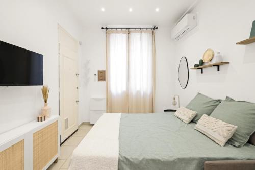 une chambre avec un lit et une télévision à écran plat dans l'établissement Le Nid Azur à 200 Mètres de la Plage, à Vallauris