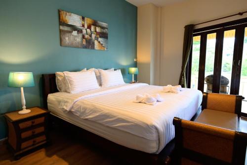 a bedroom with a large bed with towels on it at Saphli Villa in Chumphon