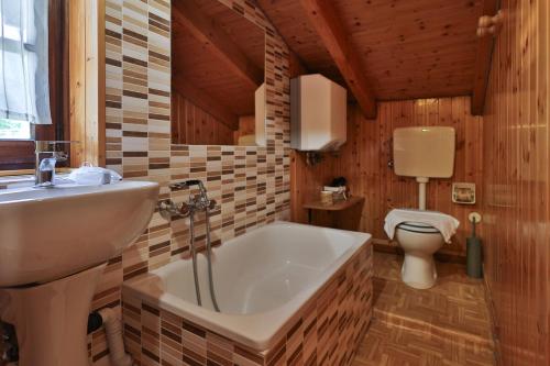 a bathroom with a tub and a sink and a toilet at Agriturismo Alberobello in Viganella