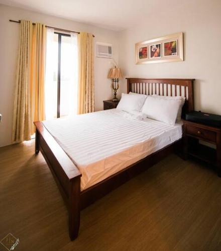 un letto grande in una camera da letto con finestra di 2 Bedroom with Balcony Tagaytay Pet-Friendly a Tagaytay