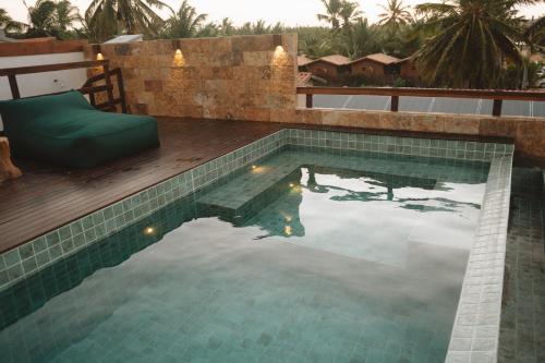 a swimming pool with a couch and a chair next to it at @Casa.Mauii - Ilha do Guajiru Luxurious House in Itarema