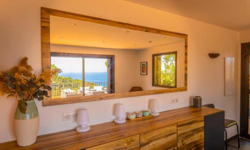 un miroir sur le mur d'une pièce avec un comptoir dans l'établissement Villa Mariposa Gaou Bénat, à Bormes-les-Mimosas