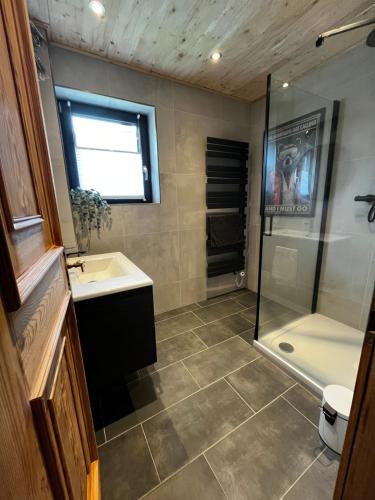une salle de bain avec une douche, un lavabo et une baignoire dans l'établissement Stunning Luxury Holiday Accommodation, Sleeps 4, Living Room, Kitchen, Games Room and Bar, à Mörtelsdorf