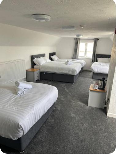 a hotel room with three beds in it at The Fox Inn in Hawkesbury
