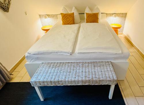 a bed with white sheets and pillows in a room at Ferienhäuser mit Seeblick direkt am Plauer See in Plau am See