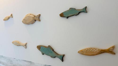 a wall with four fish decorations on it at Ferienhäuser mit Seeblick direkt am Plauer See in Plau am See