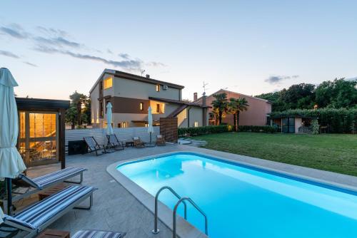 a swimming pool in the backyard of a house at APP Sandro with Common Pool in Poreč