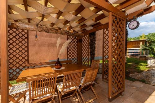 a wooden gazebo with a table and chairs at APP Sandro with Common Pool in Poreč