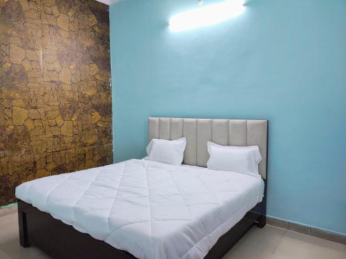 a bed with white sheets and pillows in a room at Heritage Hotel in Hardoī