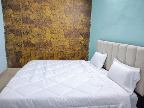 a white bed with two pillows in a bedroom at Heritage Hotel in Hardoī