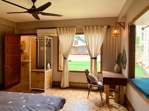 ein Schlafzimmer mit Bett, Schreibtisch und Fenster in der Unterkunft 5B Annie homestay in Nha Trang