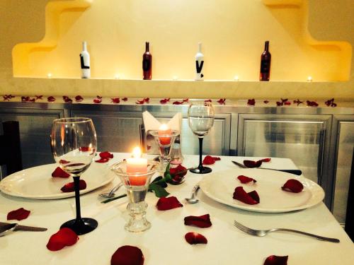 una mesa con rosas rojas y copas de vino. en Hotel Moreno, en Coatzacoalcos