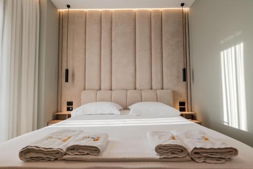 a bedroom with a large white bed with towels on it at Absolute Hotel Ksamil in Ksamil