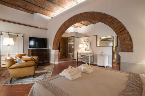 a living room with a bed and an archway at Giardino della Pieve Relais- Adult Only in Cascina