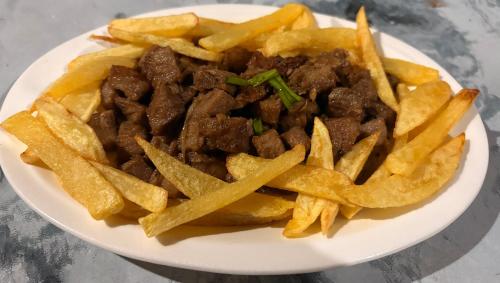 a plate of food with french fries and meat at Dosplaya Ecocamp in El Nido