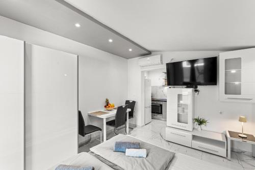 a white apartment with a kitchen and a bed and a table at APP Sandro with Common Pool in Poreč