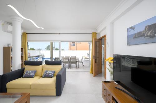 a living room with a yellow couch and a table at Porto de Mos 95 by Destination Algarve in Porto de Mós