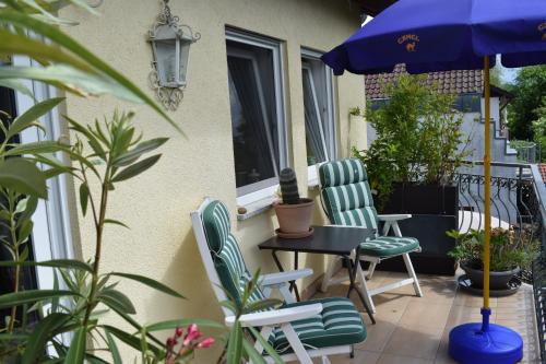 a patio with two chairs and a table and an umbrella at Ferienwohnung Ahrtalblick in Sinzig