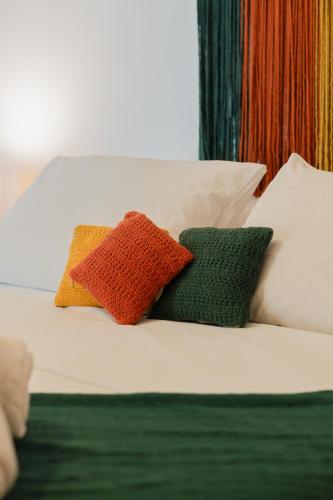 two colorful pillows sitting on top of a bed at @Casa.Mauii - Ilha do Guajiru Luxurious House in Itarema
