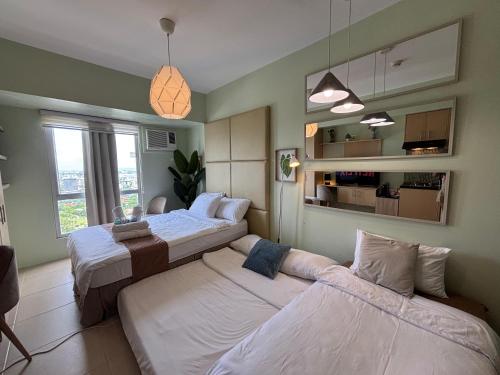 a bedroom with two beds and a large window at Avida Towers Riala T2, L&D Stays, Coffee Machine in Cebu City