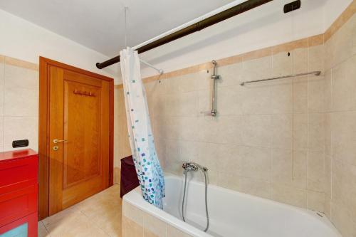 een bad met een douchegordijn in de badkamer bij Appartamento Serdes Big C2 in San Vito di Cadore